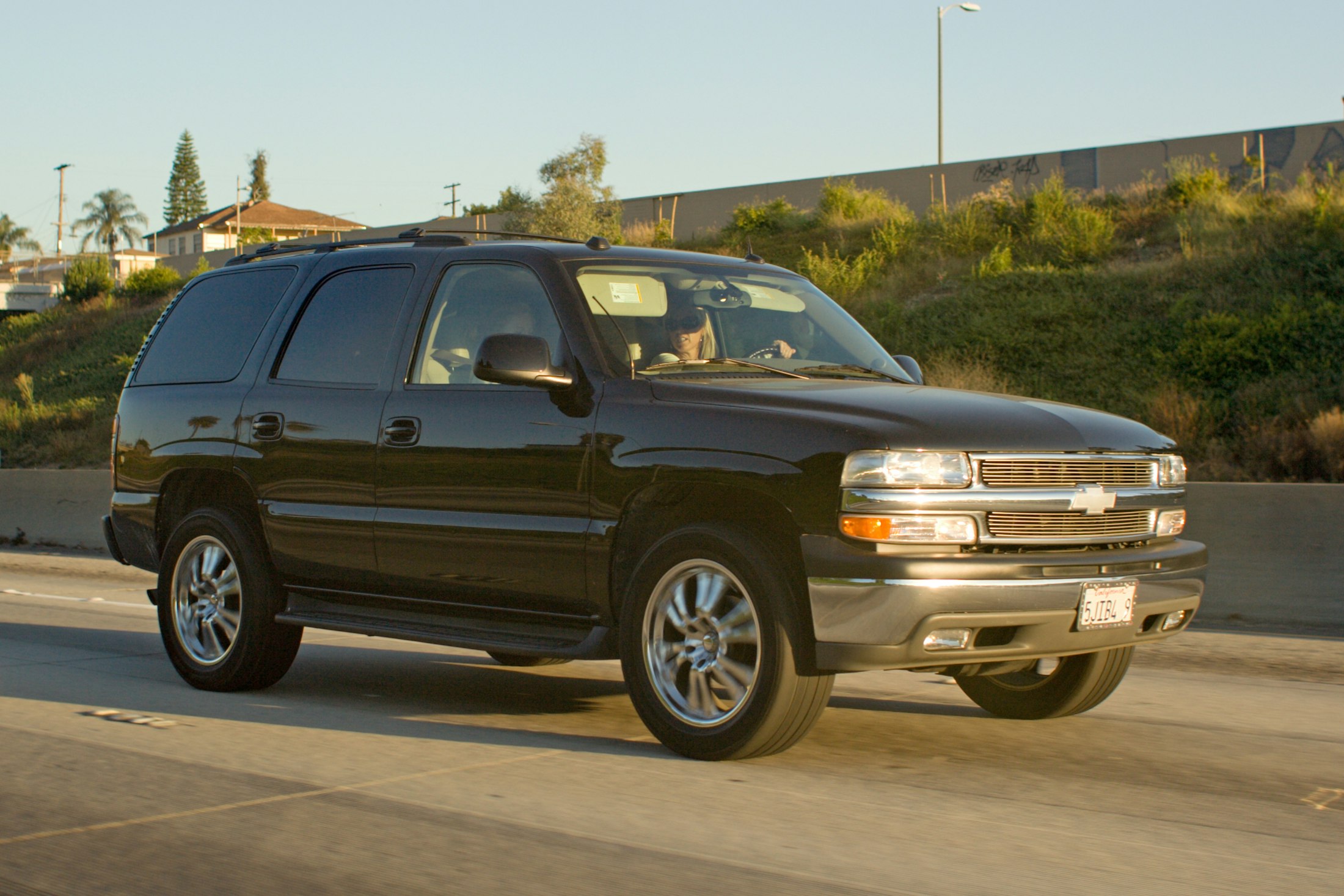 Black Chevrolet Suburban on a sunny highway