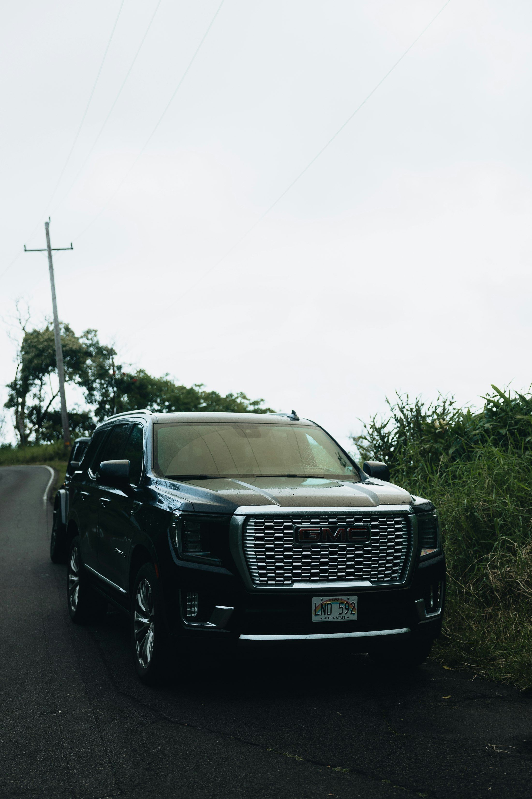 Black GMC Yukon Denali on a rural road